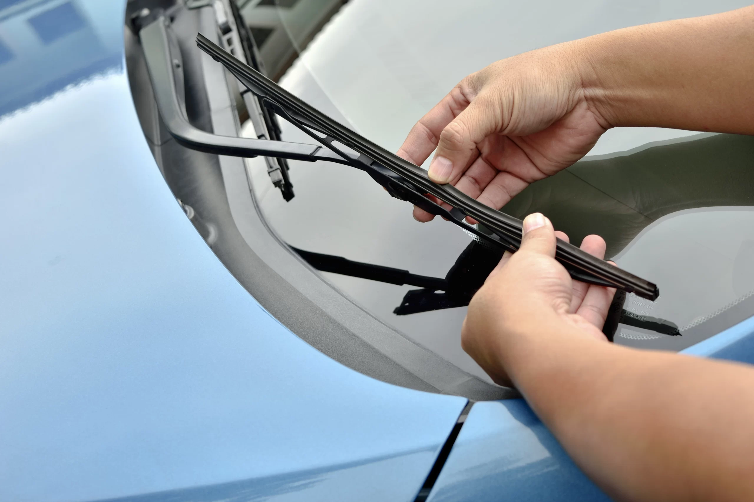 Person replacing car windshield wiper. (Mobile Auto Glass Service )